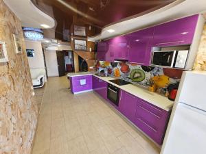 a kitchen with purple cabinets and a white refrigerator at Penthouse 15 floor in Kamianske