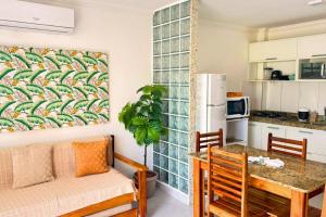 a kitchen with a table and a dining room at RESIDENCIAL MAR GALILÉIA in Porto Seguro
