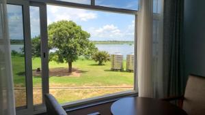 a window with a view of a tree and water at Majestic Nile Hotel Limited in Pakwach