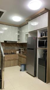 a kitchen with a black refrigerator and wooden cabinets at Villa umaya 3 Bedroom Privat Pool in Paragajen