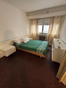 a bedroom with a bed with a green blanket on it at Departamento a 2 cuadras de la playa in Mar del Plata