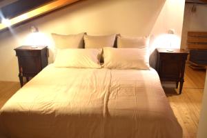 a large white bed with two night stands and two lamps at Casa ALMA 