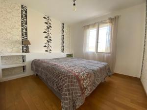 a bedroom with a bed and a window at Maison paisible in Gujan-Mestras