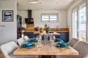 Un comedor con mesa y sillas de madera. en Maison des Flots, en Luc-sur-Mer 3 fotos más