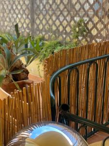a table with a chair and some plants and a fence at City House Cagliari in Cagliari