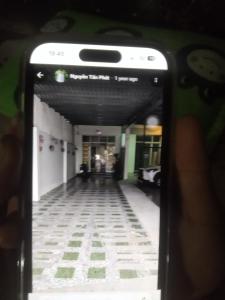 a person taking a picture of a hallway with a cell phone at Khách sạn Ngọc Dung Cs2 in Ðạo Thành