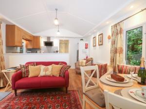 a living room with a red couch and a table at Orchard Lodge in Haywards Heath