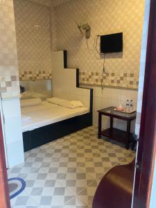 a small room with a bed and a table at Khách sạn Ngọc Dung Cs2 in Ðạo Thành