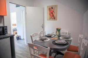 a dining room with a table with chairs and a kitchen at Kuća za odmor Grđan in Slatinski Drenovac