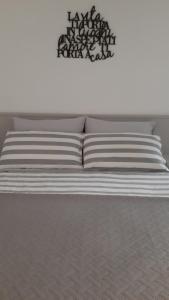 a bed with white pillows and a sign on the wall at Bed& Breakfast G&G in Porto Garibaldi