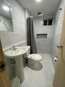 Un baño blanco con inodoro y lavabo. en Apartamento nevado reserva de curinca, en Santa Marta 11 fotos más