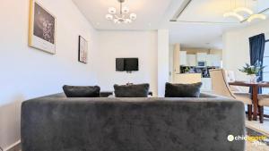 a living room with a couch and a tv at Chic & spacious studio with parking in Yaoundé