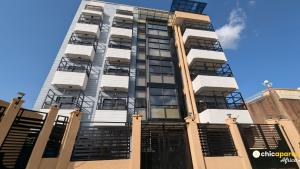 a tall white building with many windows at Chic & spacious studio with parking in Yaoundé