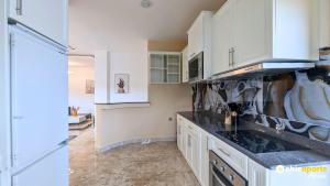 a kitchen with white cabinets and a stove at Chic & spacious studio with parking in Yaoundé