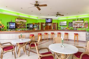 a restaurant with tables and chairs and a bar at Apartamentos Masaru in Puerto de la Cruz