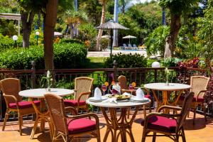 a group of tables and chairs with food on them at Apartamentos Masaru in Puerto de la Cruz