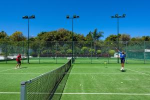 two people playing tennis on a tennis court at Apartamentos Masaru in Puerto de la Cruz
