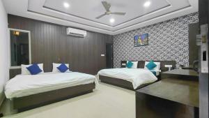 a bedroom with two beds and a ceiling fan at Hotel Elegance Udaipur in Udaipur