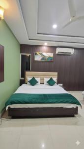 a bedroom with a large bed with green sheets at Hotel Elegance Udaipur in Udaipur +3 photos