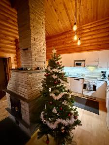 Un árbol de Navidad en una cocina con chimenea en Atmospheric log cabin by the ski tracks, en Ylläsjärvi 13 fotos más