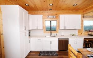 a kitchen with white cabinets and a wooden ceiling at Eagles View 2.0 - Gorgeous Mountain Views, Hot Tub, Pool Table, + Games! in Gatlinburg +49 photos