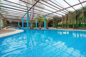a large swimming pool with a ceiling and a large swimming pool at Hotel Oviedo Teotihuacán in San Martín de las Pirámides