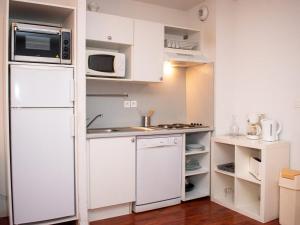 a kitchen with a white refrigerator and a microwave at Appartement Confortable 3 Pièces avec Piscine - 8 Personnes - Vignec Village, Proche Saint-Lary-Soulan - FR-1-504-18 in Vignec