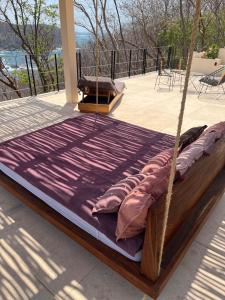 un letto con cuscini su una veranda di Villa Xololo Luxury Villa, La Boquilla Beach ad Arroyo Cruz
