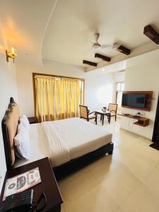 ナスドワーラにあるMETRO HOTEL Nathdwara , 500mtr 10min walking from shreenathji temple 966o9o1oo6の大きなベッドとテレビのある寝室