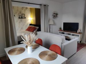a living room with a couch and a table at Studio Cosy in Feuquières