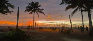 a group of people on a beach at sunset at Ethus'villahomestay in Mararikulam