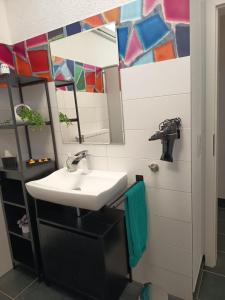 a bathroom with a sink and a mirror at Renatus Apartments in Eschau +30 photos