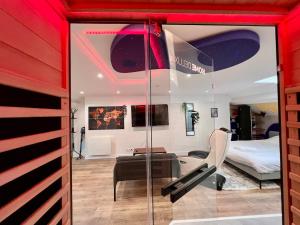a room with a glass door and a bedroom at Loft Spa Sauna Hammam Hydromassage in Reims