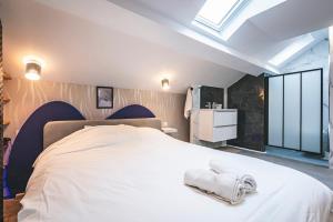 a bedroom with a large white bed with towels on it at Loft Spa Sauna Hammam Hydromassage in Reims