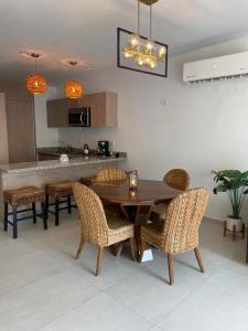 a dining room with a wooden table and chairs at Depto Moderno Oceanna frente a playa cerritos in Mazatlán