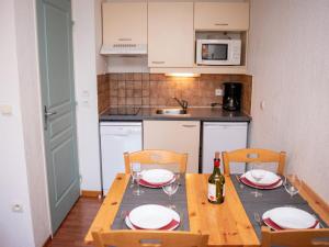 una cocina con mesa con 2 sillas y una botella de vino en 2 pièces 4 pers avec balcon et coin cuisine équipé - FR-1-504-537, en Superdevoluy