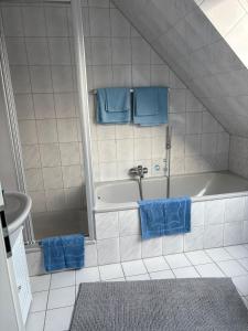 a bathroom with a tub and two blue towels at Ferienwohnung Werne in Werne an der Lippe +7 photos