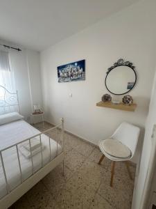 une chambre avec un lit, un miroir et une chaise dans l'établissement Kouppa Latchi, à Pólis Chrysochoús 23 autres photos