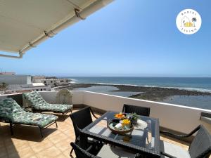a balcony with a table and chairs and the ocean at Atico del Sol by Babiniliving in Puerto del Rosario