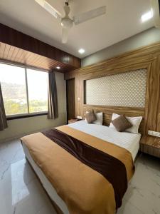 ein Schlafzimmer mit einem großen Bett und einem großen Fenster in der Unterkunft Hotel Bansuri I opposite shreenathji temple 80mtr away 966o9o1oo6 in Nāthdwāra