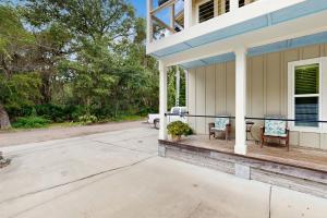 Stylish & sun-filled retreat with large patio & fireplace - near beaches & golf في فرناندينا بيتش: الشرفة الأمامية لبيت به كرسيين