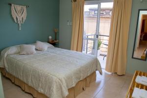 a bedroom with a bed and a balcony at Centro Peru in Paraná