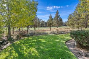 un cortile con erba e alberi in una giornata di sole di 11 Tournament home a Sunriver Altre 46 foto