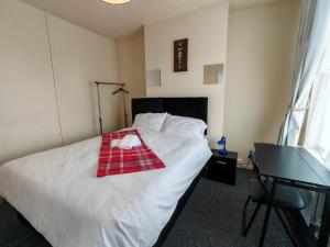 ウォルヴァーハンプトンにあるCentral Wolverhampton Stayのベッドルーム1室(白いベッド1台、赤いタオル付)