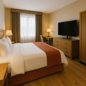 een hotelkamer met een bed en een flatscreen-tv bij Soklena Homestay 