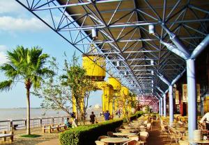 a building with tables and chairs next to the beach at casa da Maria aconchegante in Belém