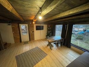 a living room with a table and a tv and some windows at Pustirnik in Rakhiv