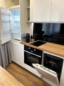 a kitchen with a stove and an open refrigerator at TK Komfortowy Apartment Piła w centrum Netflix Światłowód w cenie in Piła