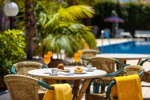 a table with food and drinks on it next to a pool at Apartamentos Masaru in Puerto de la Cruz