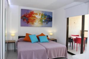 1 dormitorio con 1 cama y una pintura en la pared en Apartamentos Vistamar, en Benidorm